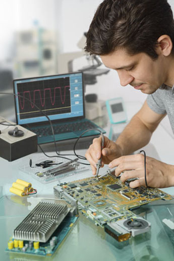 Um engenheiro desenvolvendo projeto eletrônico em cima de uma bancada