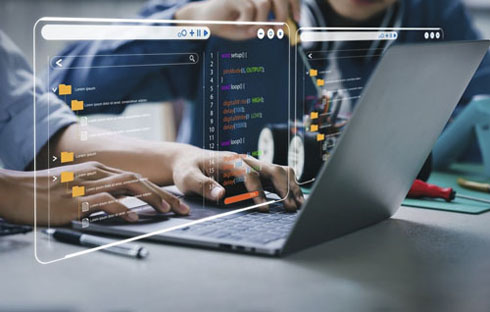 Engenheiro sentado programando o firmware de um carrinho de brinquedo com um ajudante